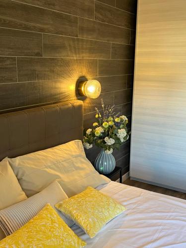 a bedroom with a bed with a vase of flowers at Garda Flow Holiday Home in Lonato del Garda