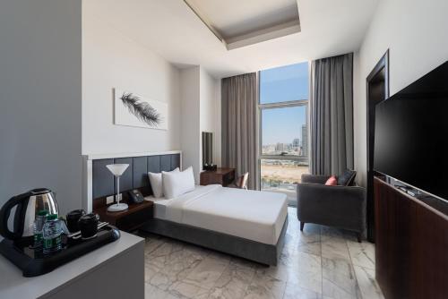 a hotel room with a bed and a television at HDB Al Sahafa in Riyadh