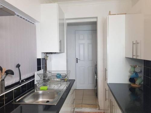 a kitchen with a sink and a white door at Kunda House Parkhill in Birmingham