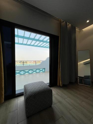 Zimmer mit einer großen Glasschiebetür zum Balkon in der Unterkunft غرفة صالة بلكونة على الشاطئ - عوائل in Durrat Al-Arus