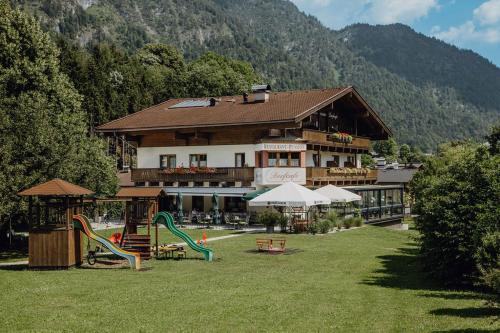 a large building with a playground in the grass at Dorfcafe Unken Hotelpension sWirtshaus im Dorf in Unken