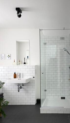 a white bathroom with a shower and a sink at Zehuus mit Domblick und Dachterrasse in Cologne
