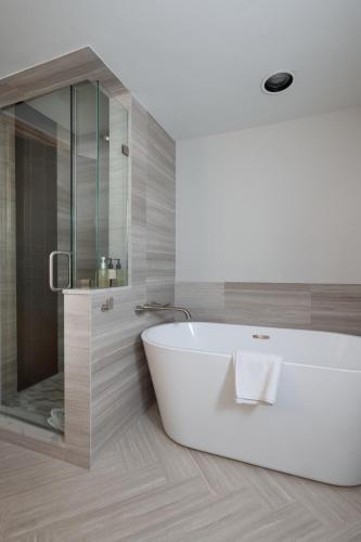 a bathroom with a white tub and a glass shower at Gravity Haus Vail in Vail