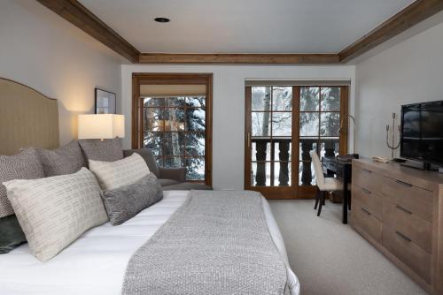 a bedroom with a bed and a desk and a television at Gravity Haus Vail in Vail