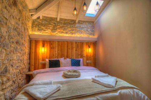 ein Schlafzimmer mit einem großen Bett in einer Steinmauer in der Unterkunft Cozy Villa near Mount Parnassos in Arachova