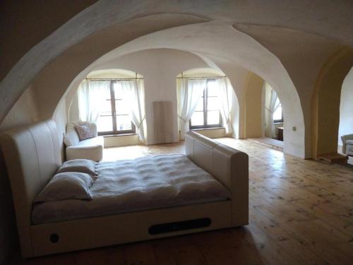 Residence Spillenberg Bridal Suite - Svadobna cesta في ليفوتشا: غرفة معيشة مع سرير في ممر مع نوافذ