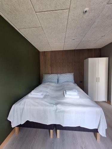 a bedroom with a large bed with two towels on it at EngholmBB in Odense