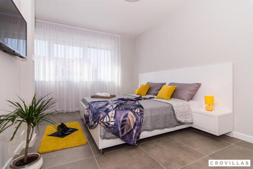 ein weißes Schlafzimmer mit einem Bett und einem Fenster in der Unterkunft Kastel One in Kaštela