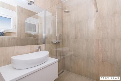 ein Badezimmer mit Waschbecken und Glasdusche in der Unterkunft Kastel One in Kaštela