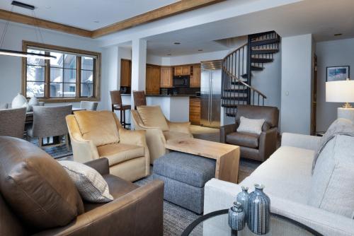 a living room with a couch and chairs and a staircase at Gravity Haus Vail in Vail