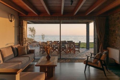 a living room with a couch and a view of the ocean at Real Life Homes luxurious seafront villas each with their own private pools in Korakokhórion