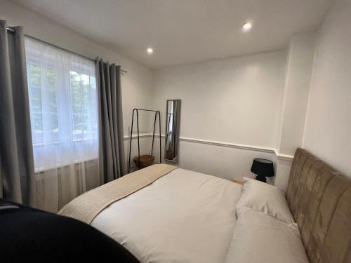 a small bedroom with a bed with a window at Cosy Single Room for ONE person in Bromley