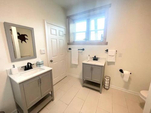 a bathroom with two sinks and a toilet and a window at The Penthouse in Downtown in Fayetteville
