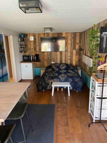 a bedroom with a bed and a table in it at Beach House met badkamer, boxspring & airco in Schoonebeek
