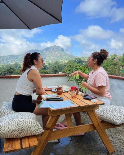 two women sitting at a picnic table with a view at Hospedaje Casa Teotleco in Tepoztlán