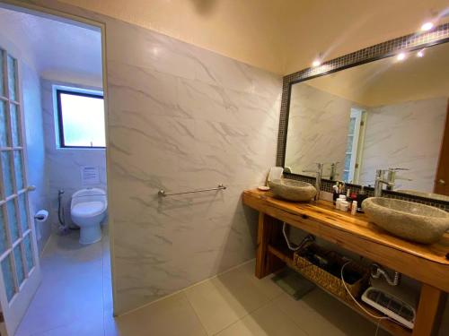 a bathroom with two sinks and a mirror and a toilet at Parcela Olmué La Luz in Olmué