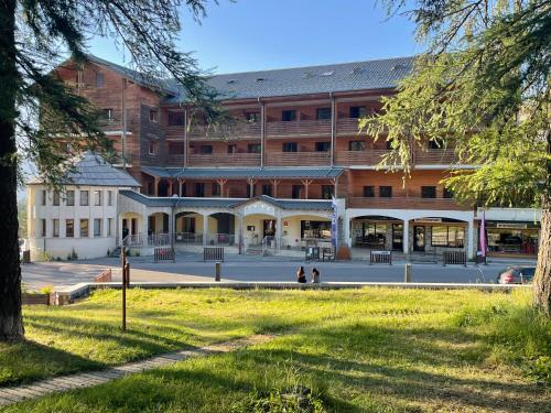 a large building with a courtyard in front of it at 2 pièces, au pied des pistes ds Résidence Gd Hôtel in Valberg
