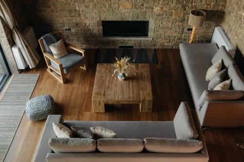 a living room with a couch and a table at Real Life Homes luxurious seafront villas each with their own private pools in Korakokhórion