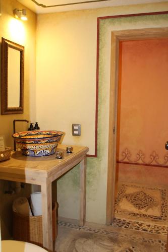 a bathroom with a sink and a bowl on a table at Hotel Casa Caro in Bernal