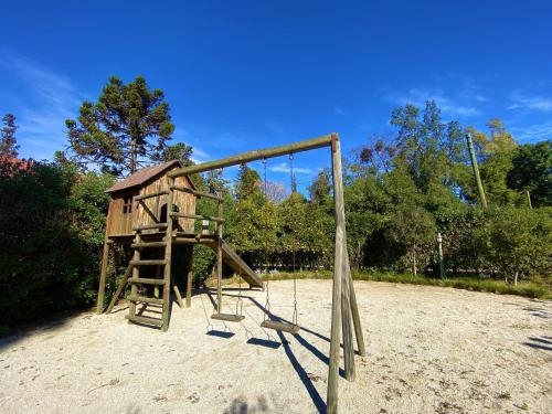 a wooden playground with a swing at Parcela Olmué La Luz in Olmué
