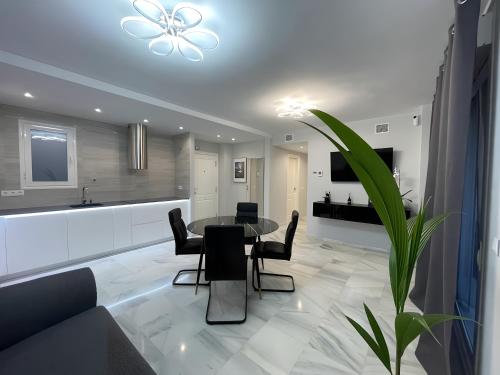 贝纳尔马德纳Luxury apartment Benalmadena First line的配有桌椅的厨房和客厅