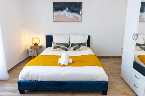 une chambre avec un lit avec un ours en peluche dessus dans l'établissement Joli Studio Climatisé 'Alma 4' - Cœur de Béziers - Wifi Fibre - Netflix, à Béziers