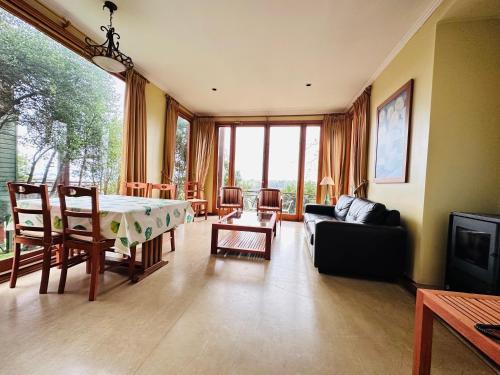 a living room with a table and a couch at Hotel y Cabañas Punta Larga - Caja Los Andes in Frutillar