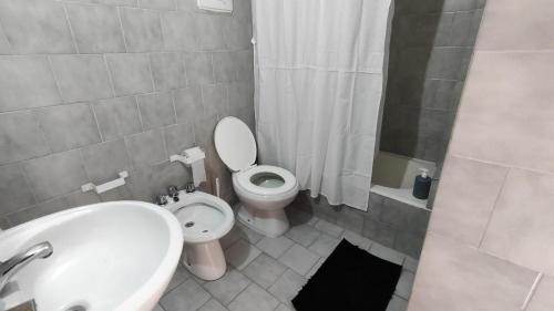a bathroom with a toilet and a sink and a shower at Departamento en excelente ubicación con balcón - Próxima B&B in Cordoba