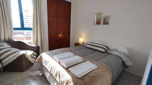 a bedroom with a bed with towels on it at Departamento en excelente ubicación con balcón - Próxima B&B in Cordoba