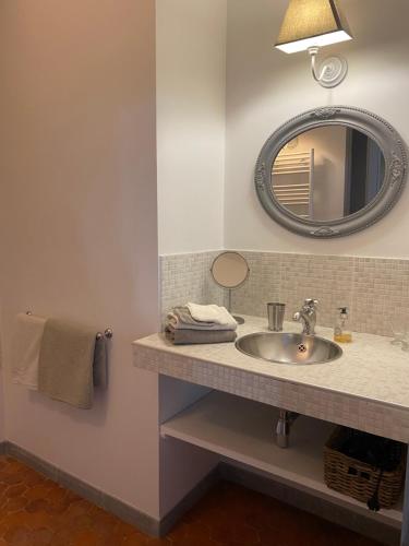 a bathroom with a sink and a mirror at Le "M" Maison d hôtes in Riez