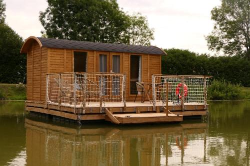 a tiny house on a dock in the water at Les Cabanes Flottantes in Givrauval