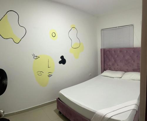 - une chambre avec un lit avec des étiquettes murales dans l'établissement Apartamento 202, à Carthagène des Indes