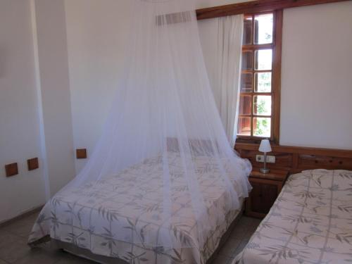 a bedroom with a bed with a mosquito net at Elze Hotel in Oludeniz
