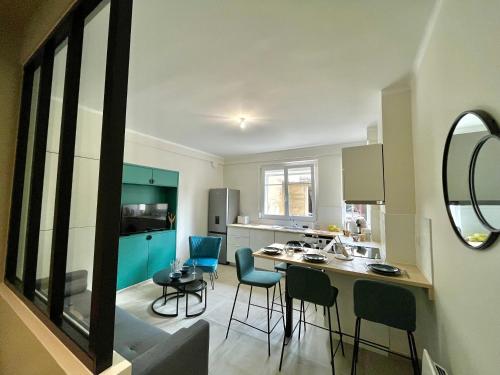 une cuisine avec des armoires bleues et une table et des chaises dans l'établissement HONEY - Reims Hypercentre, à Reims