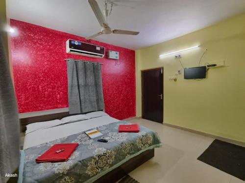 a bedroom with a bed and a red wall at Hotel Bobby house 450m from beach & 1 km from temple in Puri