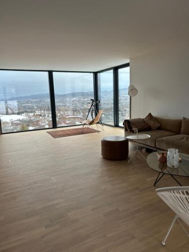 a living room with a couch and floor to ceiling windows at Villa Trondheim in Trondheim