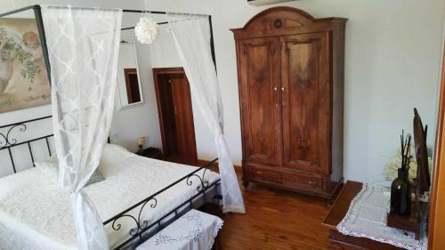 a bedroom with a canopy bed and a wooden cabinet at Traghetto vecchio house in Cavallino-Treporti