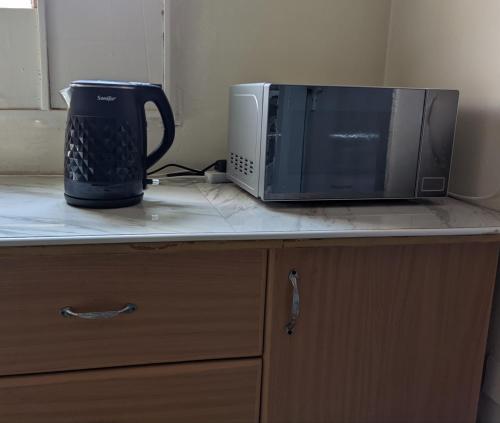 a microwave and a toaster oven sitting on a counter at Secure Apartment in Kampala in Kampala