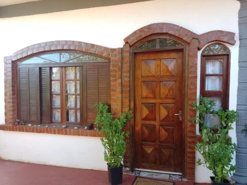 uma casa com uma porta de madeira e uma janela em Flor de Lis em Porto Iguaçu