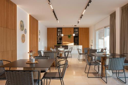 a restaurant with tables and chairs and a kitchen at Essenza Relais Contemporaneo in Cisternino