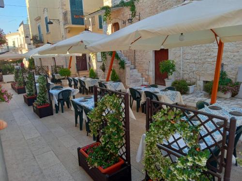 a patio with tables and chairs with plants and umbrellas at B&B Al Castello in Sammichele di Bari