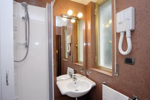 a bathroom with a sink and a shower and a mirror at Hotel Maria Nella in Bardineto