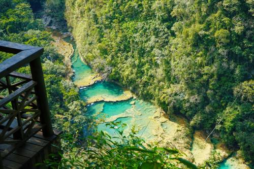 an aerial view of a river in a forest at El Retiro Lanquin in Lanquín