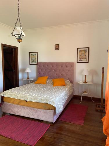 a bedroom with a large bed with orange pillows at Casa do Cabeço in Benedita
