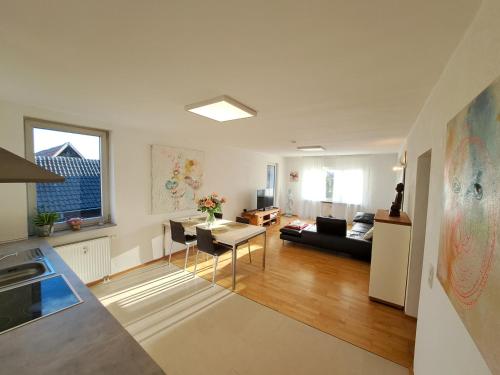 a kitchen and living room with a couch and a table at Art & Living Apartment in Schoneck