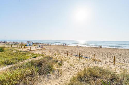 a sandy beach with people in the ocean at Sunny apartments in La Mata, Azul Beach 2 in Torrevieja