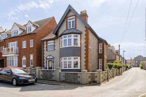 a house with a car parked in front of it at Westward House - Norfolk Cottage Agency in Sheringham