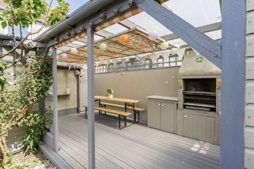 a patio with a table and an outdoor kitchen at Westward House - Norfolk Cottage Agency in Sheringham