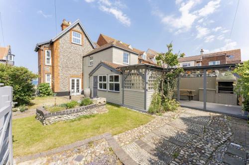 an exterior view of a house with a yard at Westward House - Norfolk Cottage Agency in Sheringham