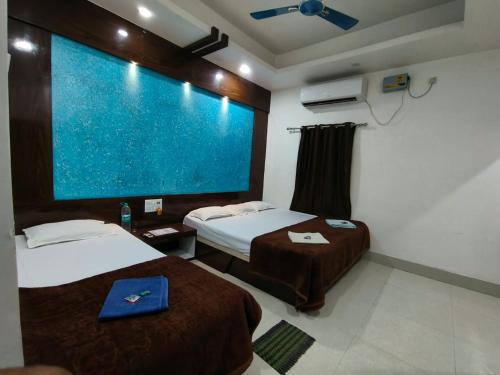 a hotel room with two beds and a large screen at Hotel Bobby house 450m from beach & 1 km from temple in Puri